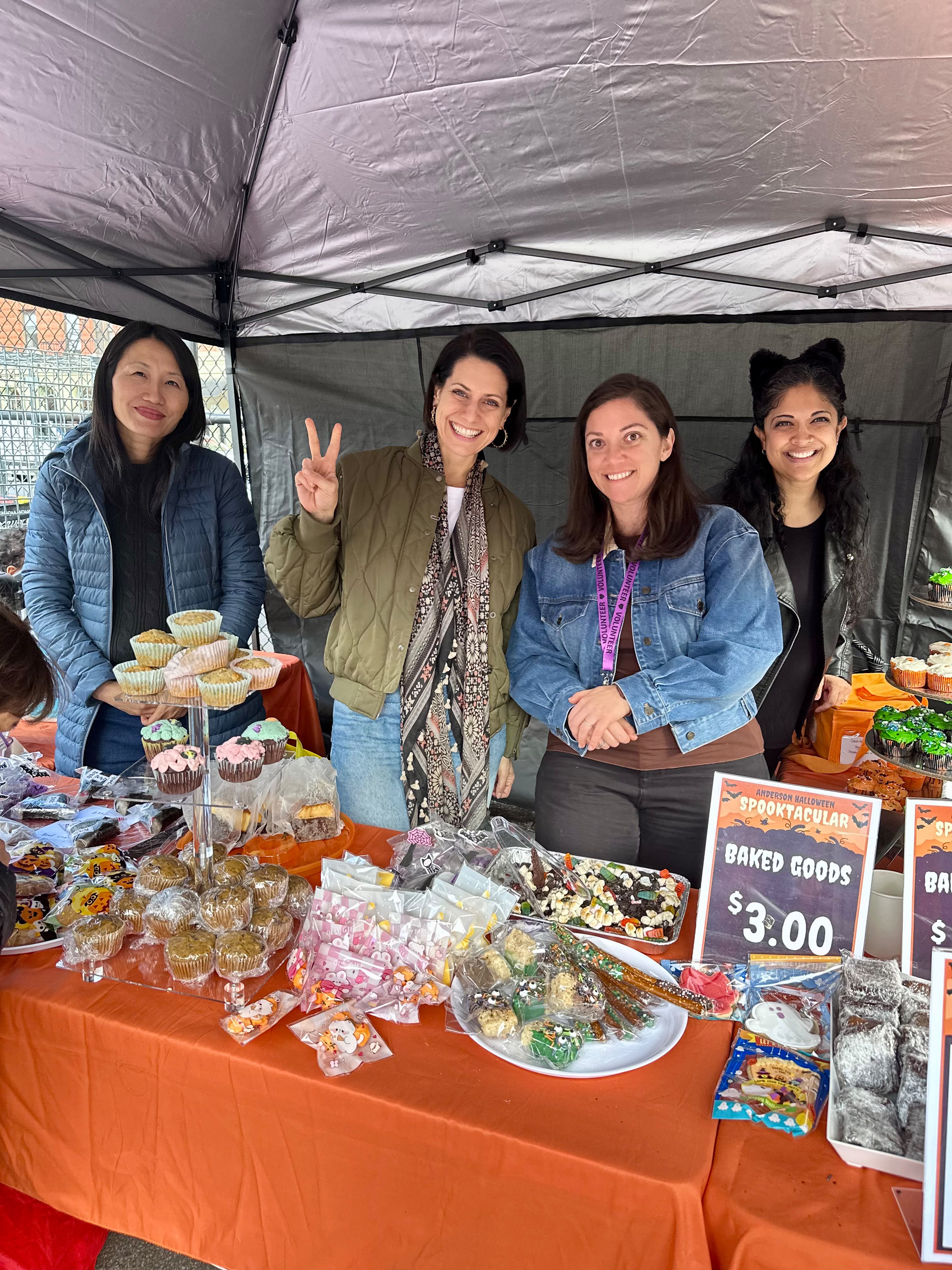 Four Anderson parent volunteers behind the Spooktacular bake sale table