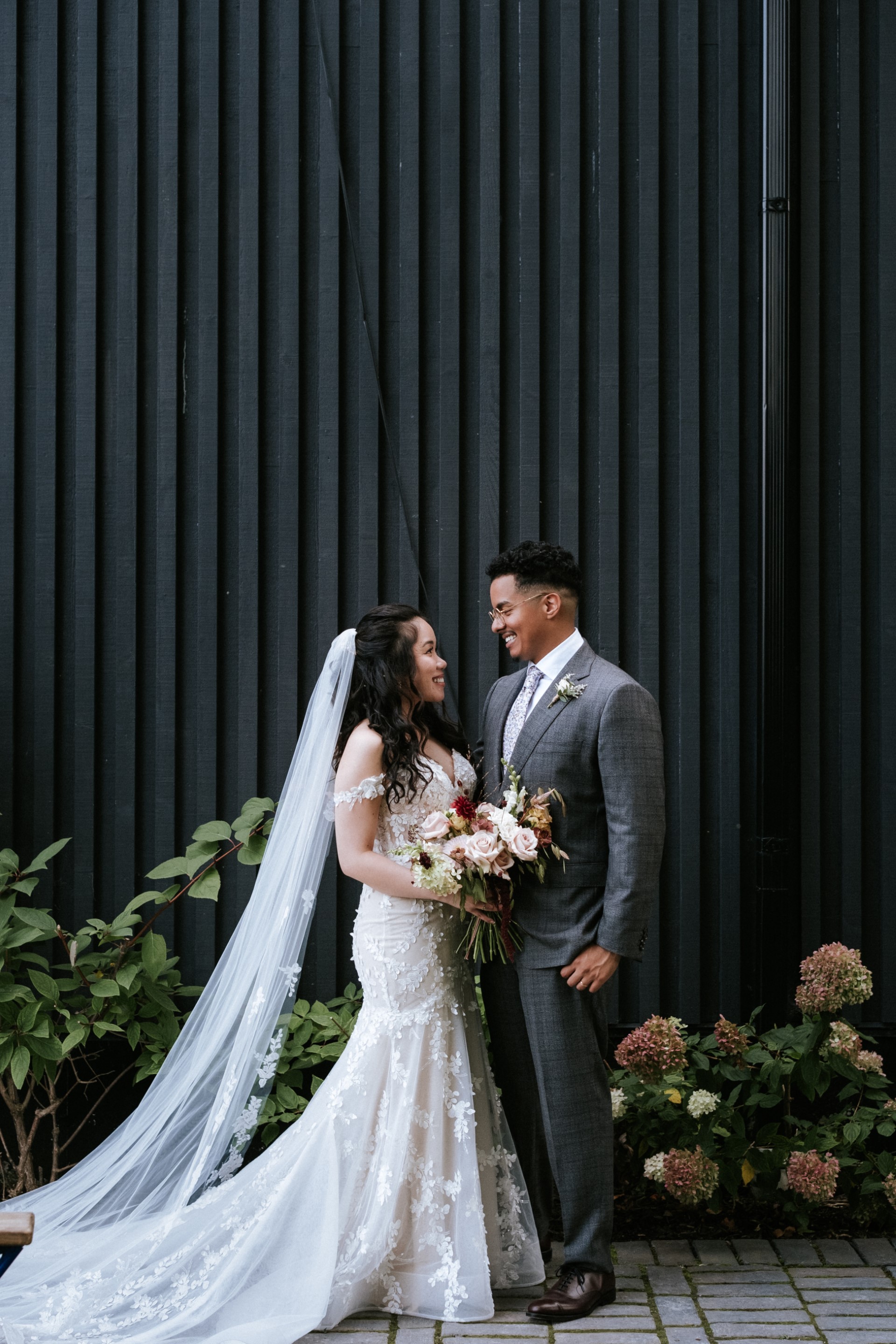 Bride and groom outdoors, groom wearing a grey suit