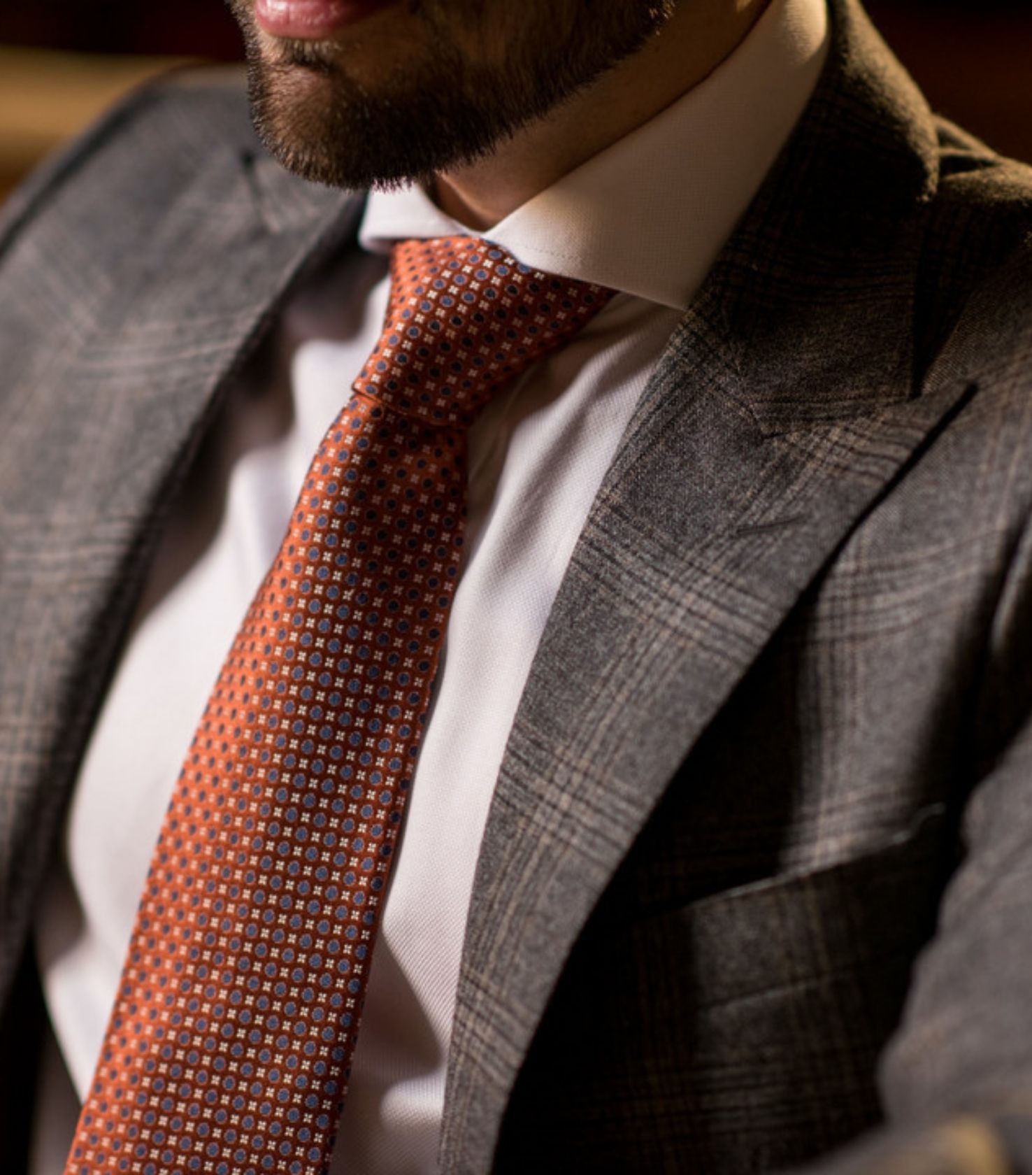 Man wearing a tailored grey suit and tie
