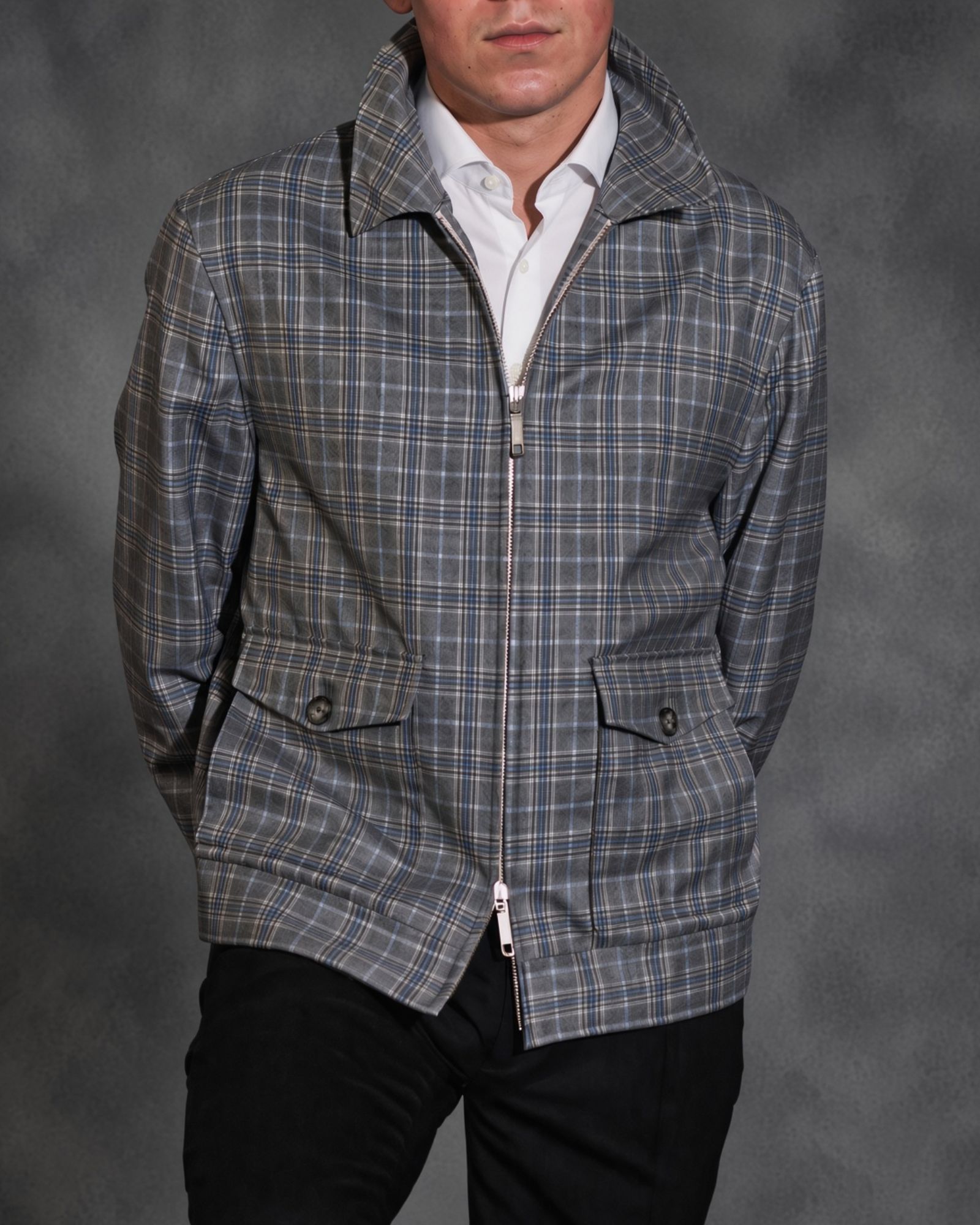 Man wearing a grey checked zip-front jacket over a white shirt
