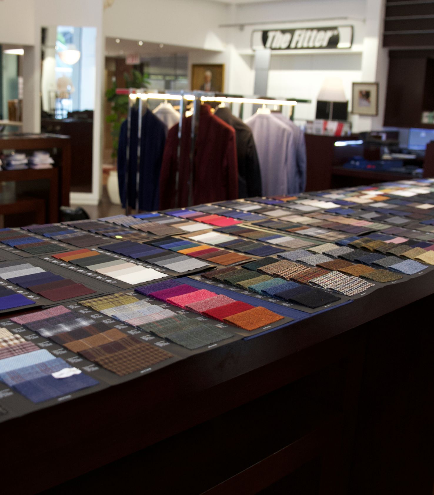 Suiting fabric swatches displayed on a table in the Rego Bespoke showroom