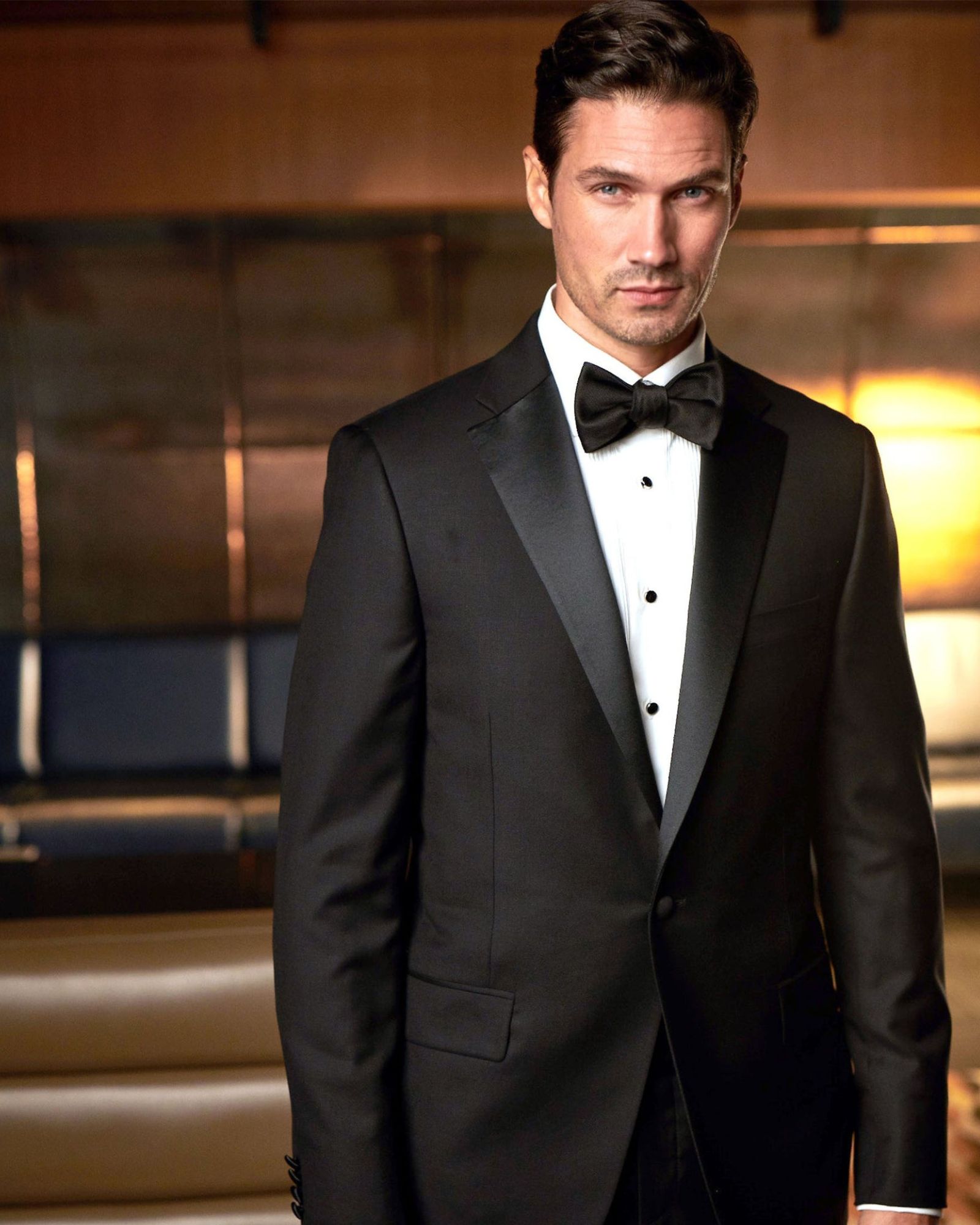 Man wearing a black tuxedo with satin lapels and bow tie