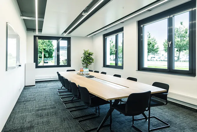 Meetingraum mit einem langen Tisch und 14 Stühlen