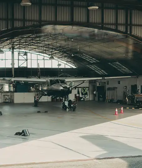Flugzeug steht in einem Hangar mit vielen Werkzeugen und technischen Geräten an den Wänden