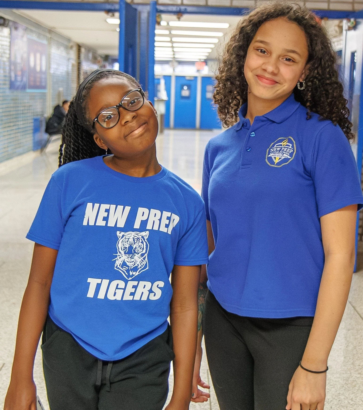 Two New Prep students smiling in school uniforms in hallway