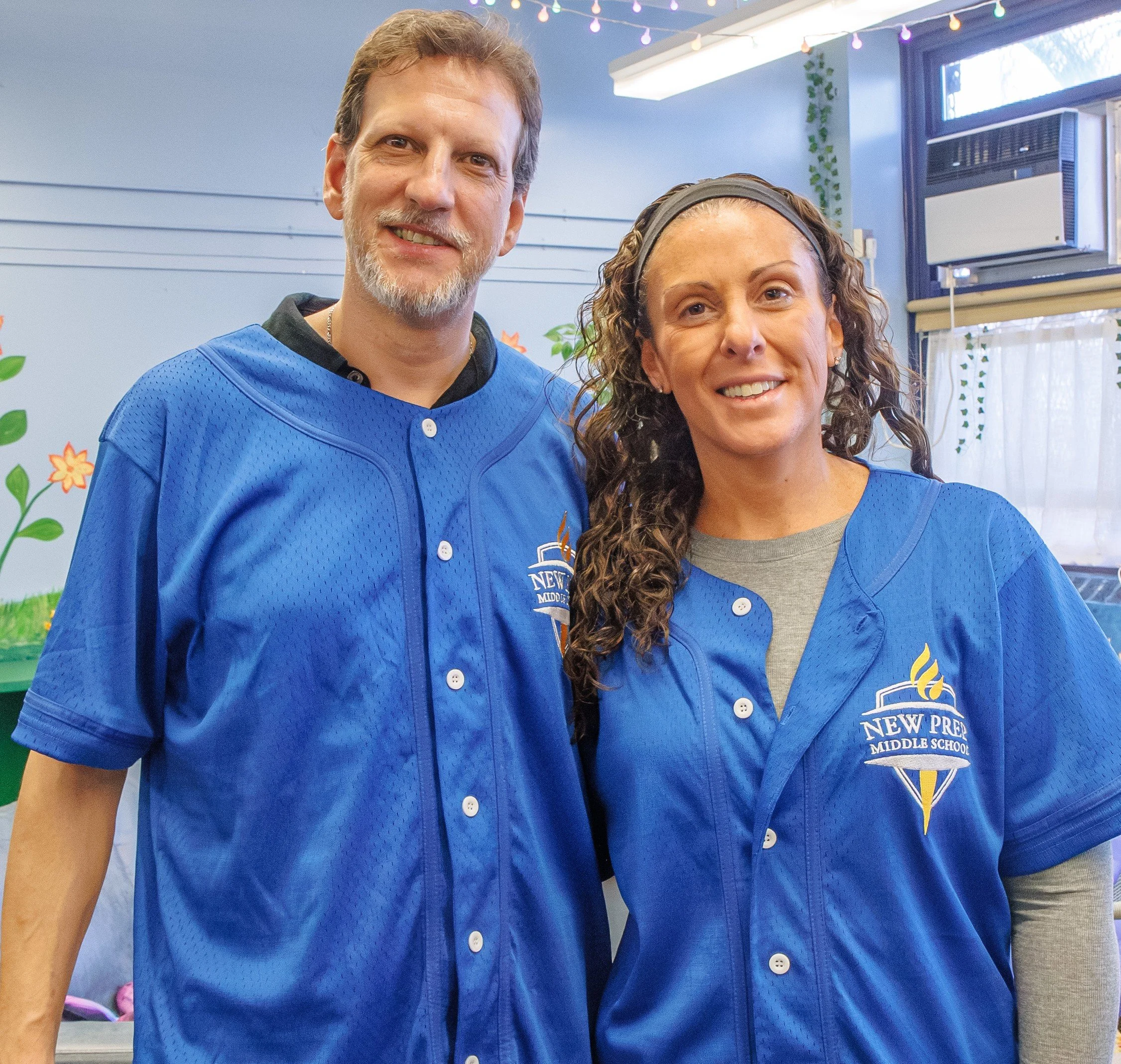 Two New Prep Middle School staff members wearing blue school jerseys