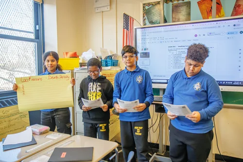 Four middle school students presenting a project in class