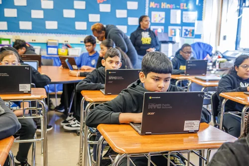 Students working on NYC school Chromebooks in a classroom