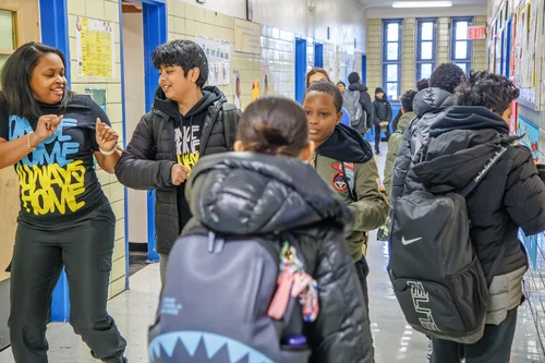 Students socializing and laughing together in a school hallway