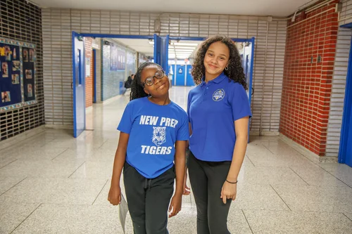 Two New Prep Tigers students smiling in school hallway