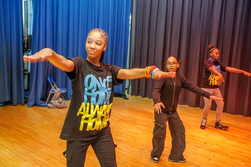 Students rehearsing a dance routine on a school stage