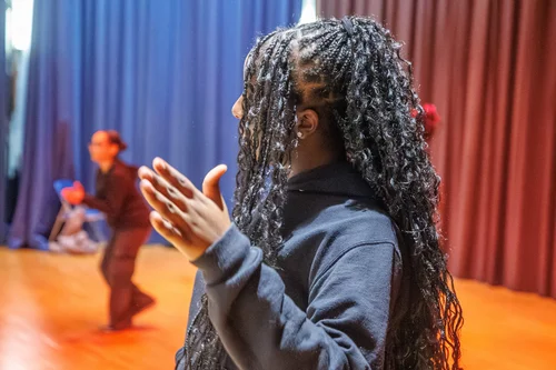 Student performing on stage during a school theater production