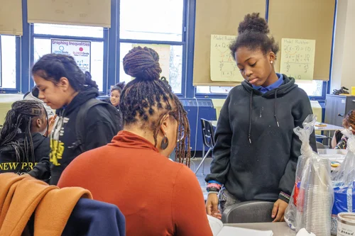 Students working together at a classroom table during an activity