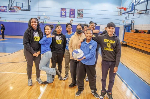 New Prep Tigers students posing with volleyball in school gymnasium