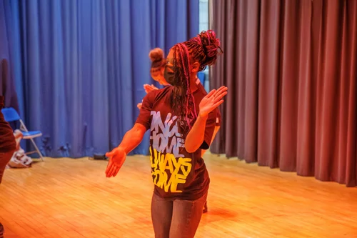 Student performing a dance routine on a school stage