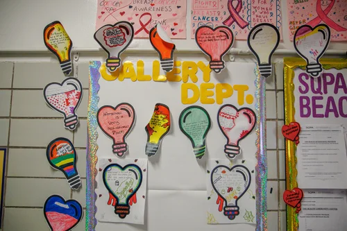 Student artwork display featuring light bulb and heart cutouts on bulletin board