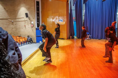Students dancing on a school auditorium stage during a performance