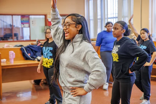 Students practicing dance moves during an indoor school activity