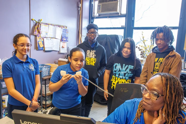 Students and teacher gathered around a school office desk