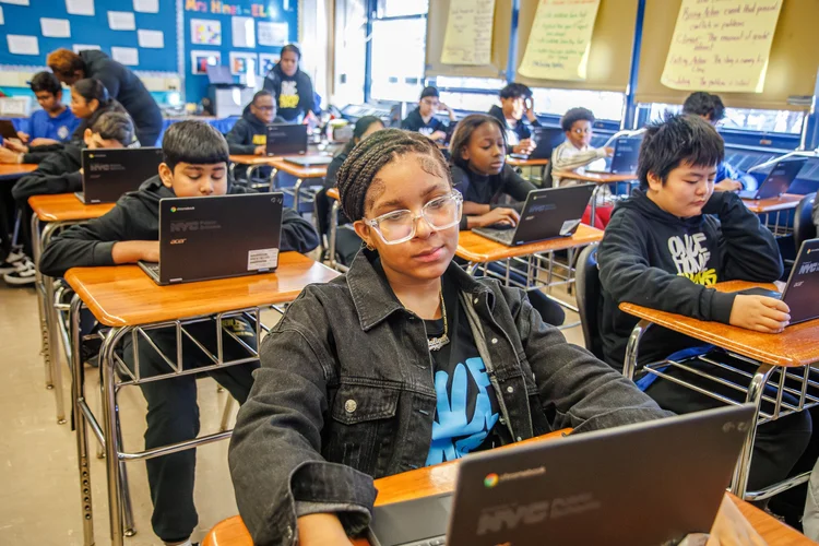 Middle school students working on Chromebooks in a classroom