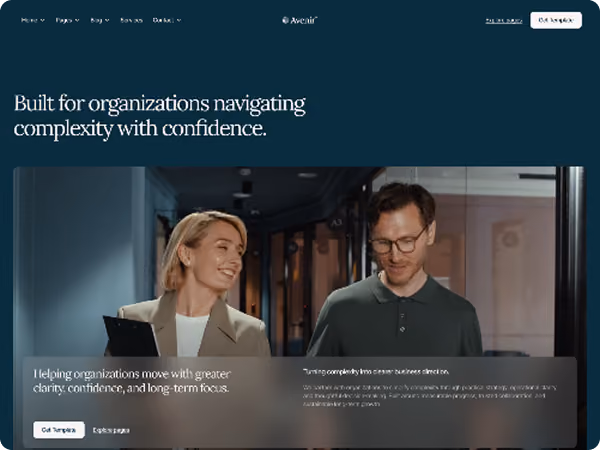 Two professionals, a woman and man, discussing work in an office, smiling and engaged in conversation.