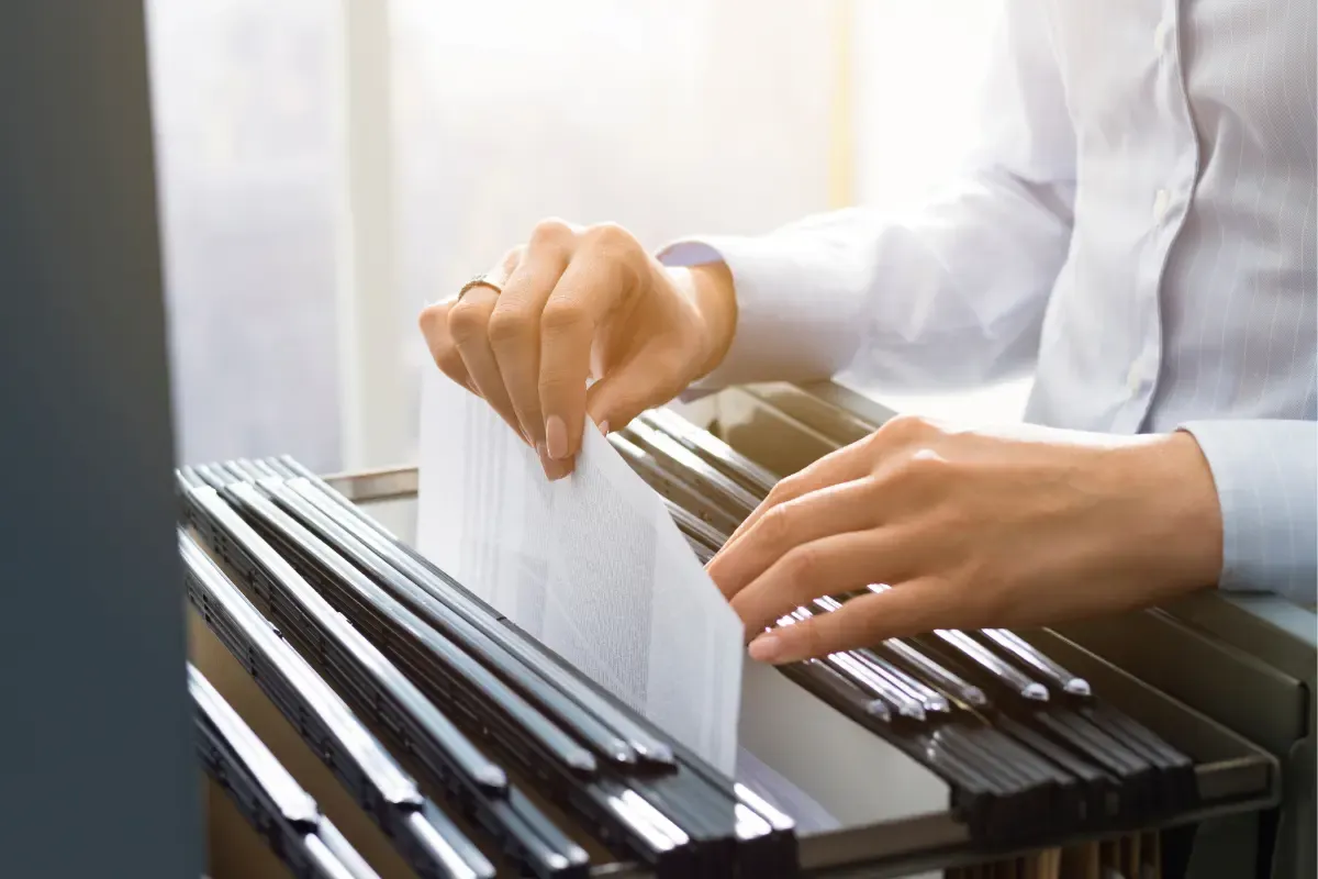 man taking a paper out of cabinet - How To Close A Business With The IRS