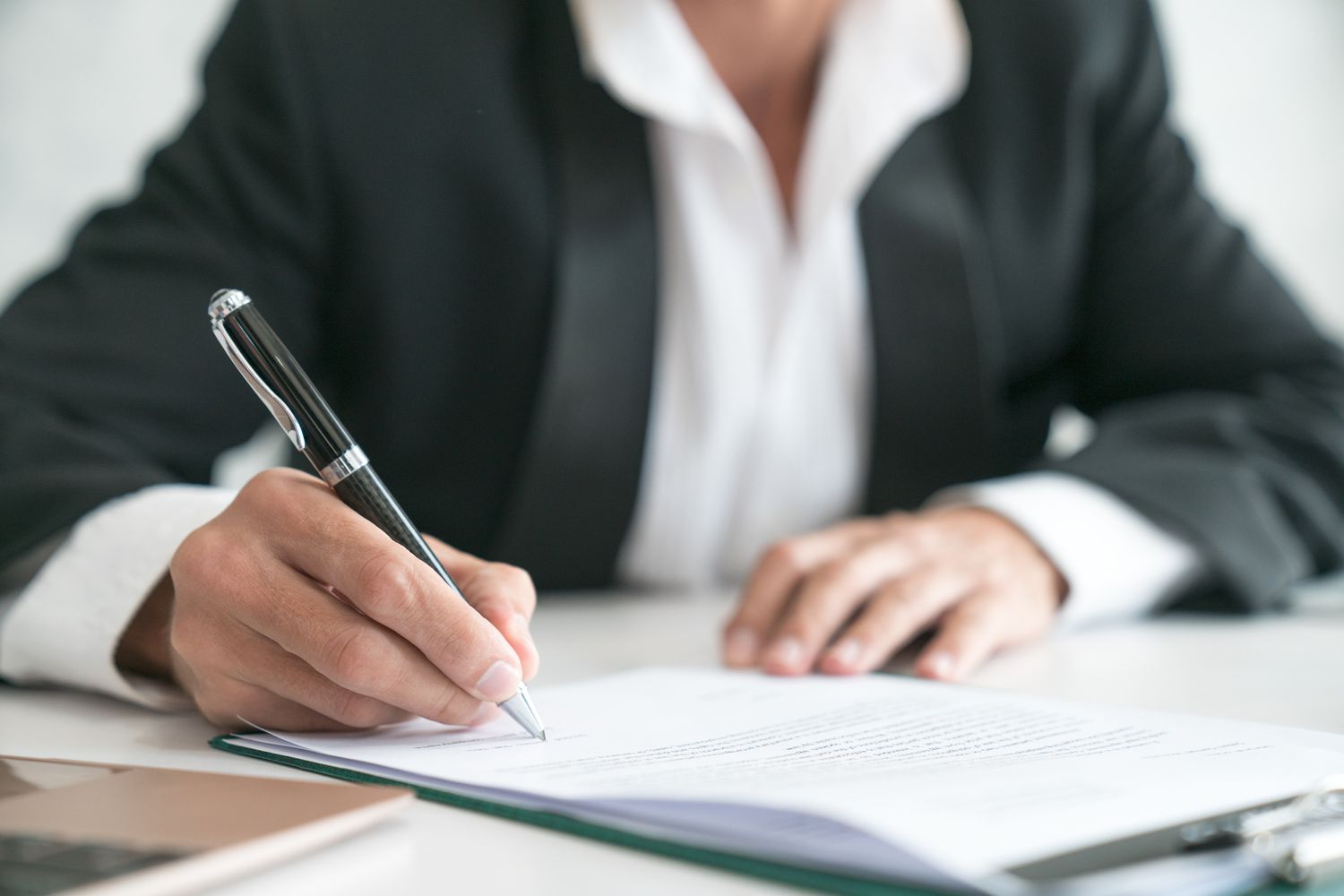man signing a document - How To Dissolve an LLC in New Mexico