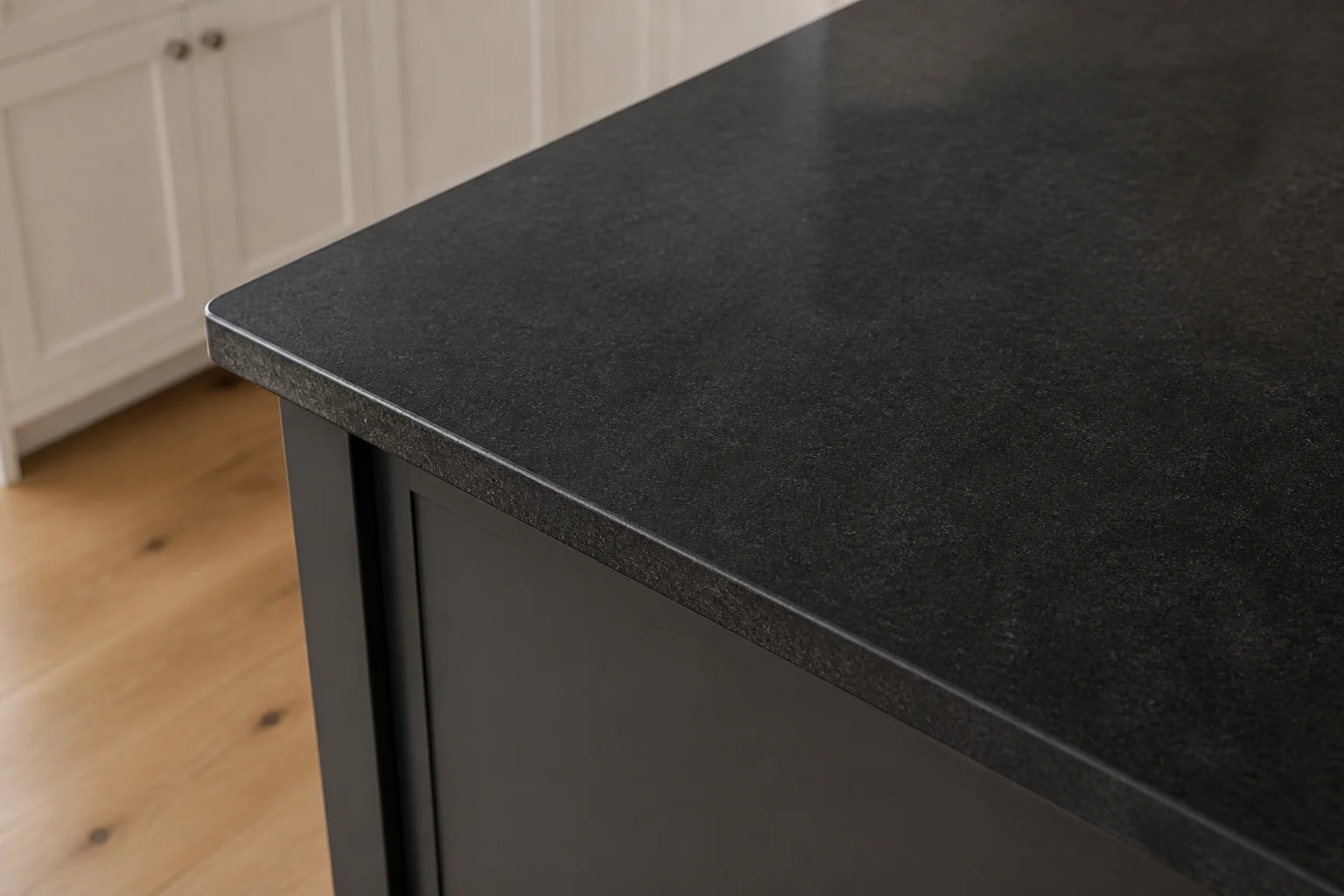 Low-sheen leathered texture and subtle mineral movement on the Absolute Black granite island.