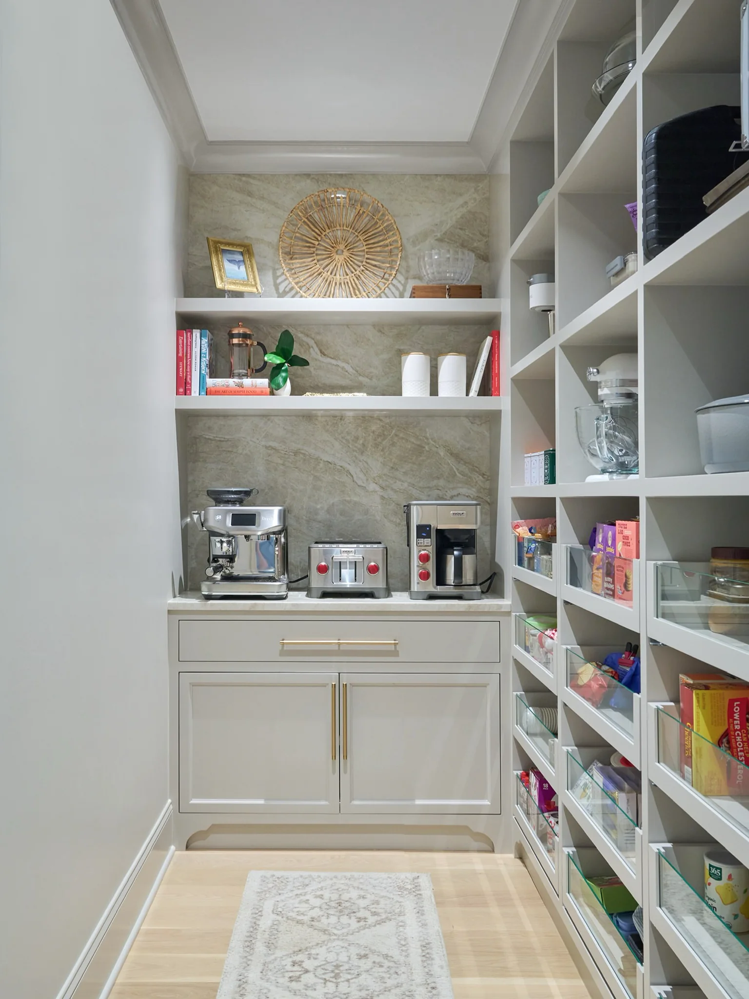 Taj Mahal quartzite backsplash and counter in a coffee pantry with white cabinetry and open shelves.