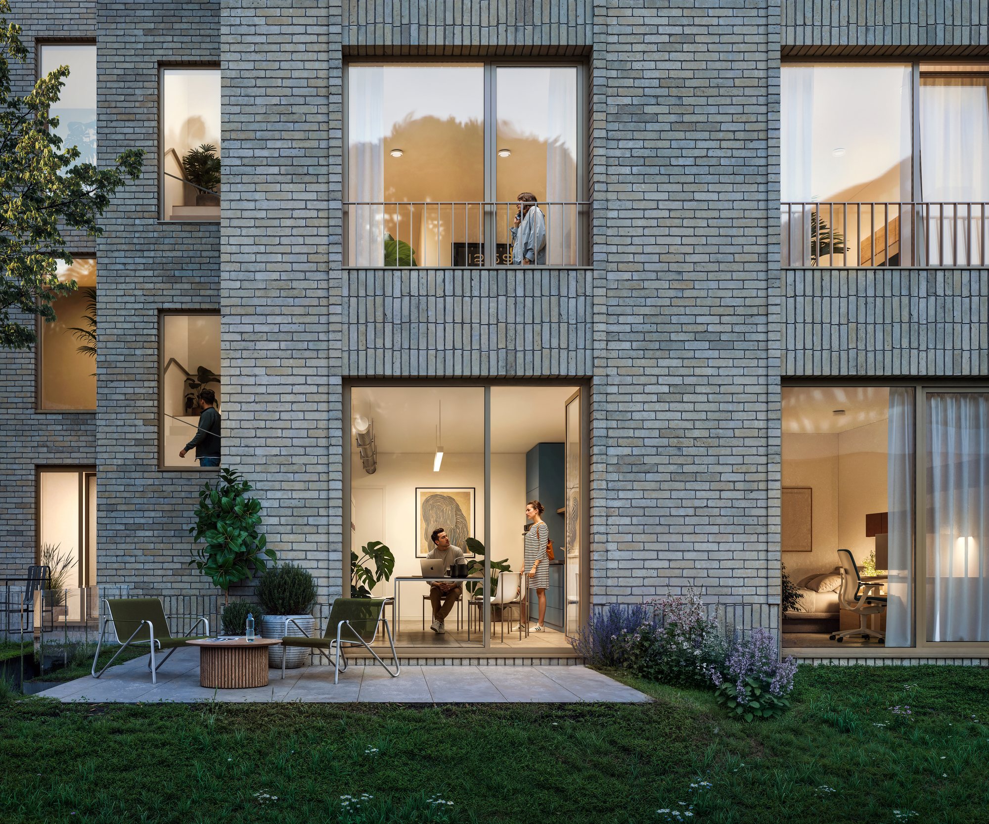 Binnenstedelijk woonproject bij avondlicht, met terras en tuin aan de gelijkvloerse woningen