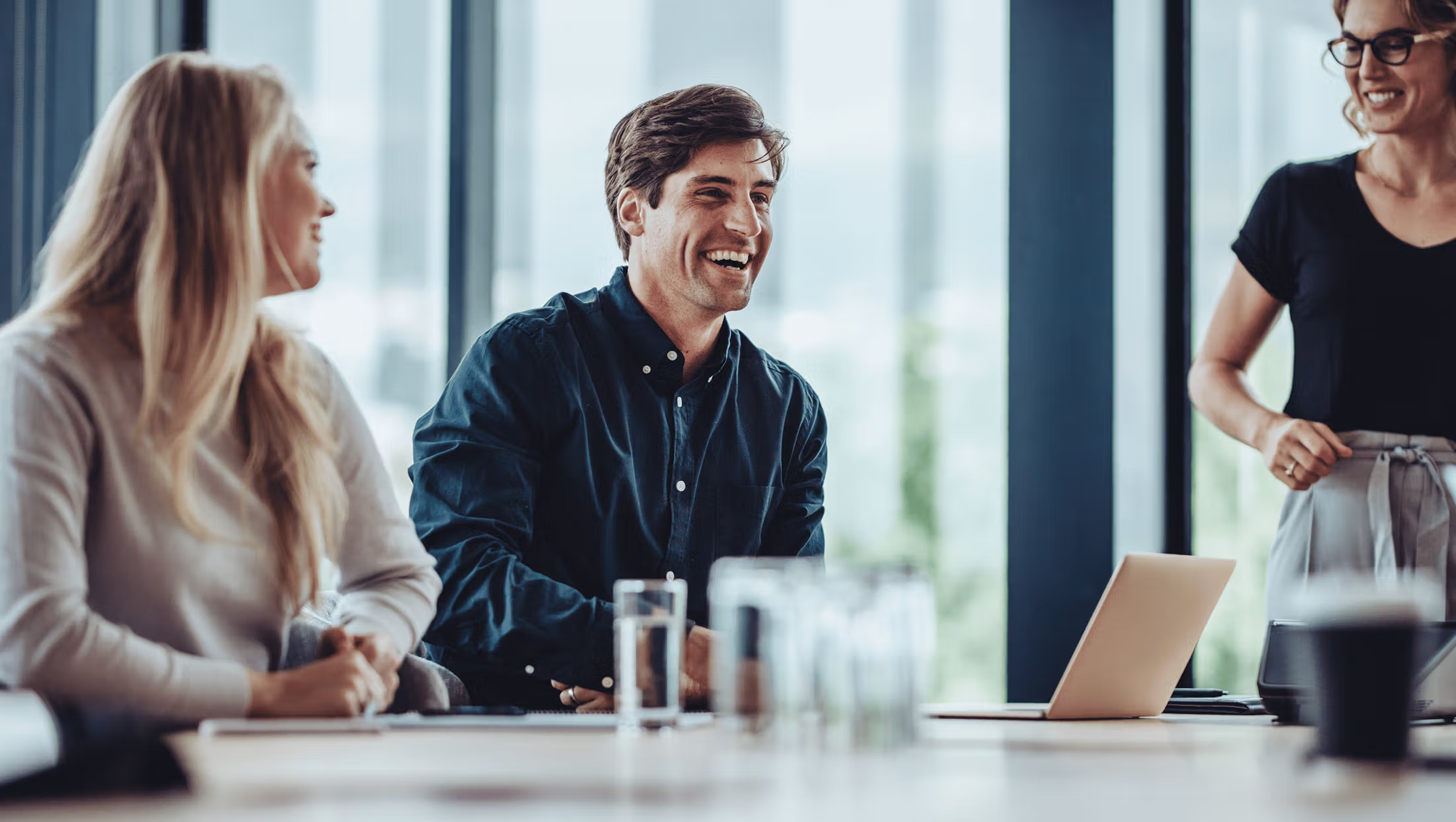 People smiling and talking in an office setting