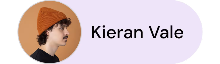 Profile photo of a man with curly hair wearing an orange beanie against a brown background next to the name Kieran Vale.