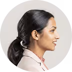 Profile of a middle-aged woman with short gray hair wearing a black turtleneck and hoop earrings.