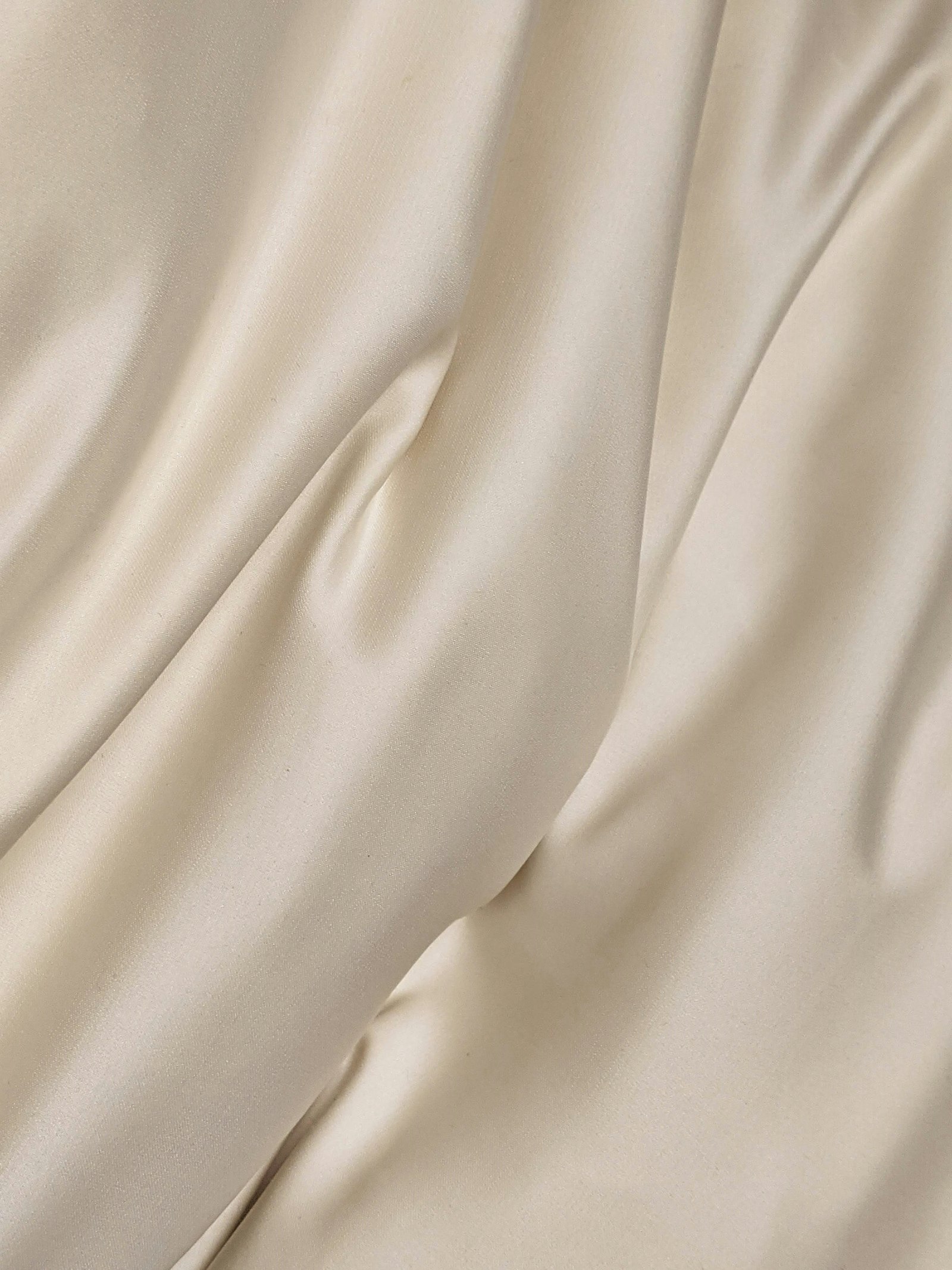 Softly draped cream silk fabric, abstract