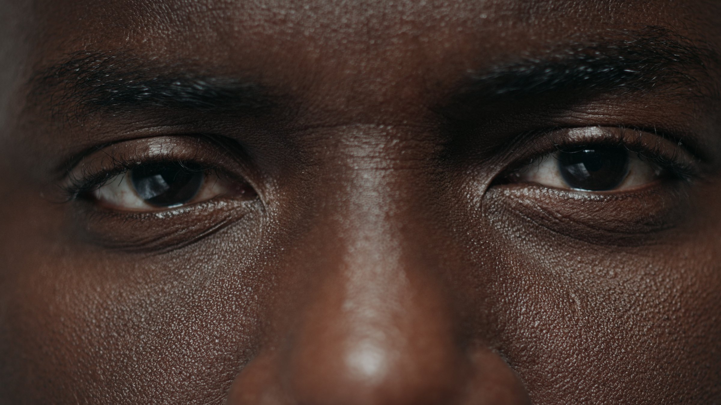Close-up of a man's brow and eyes in even, natural light
