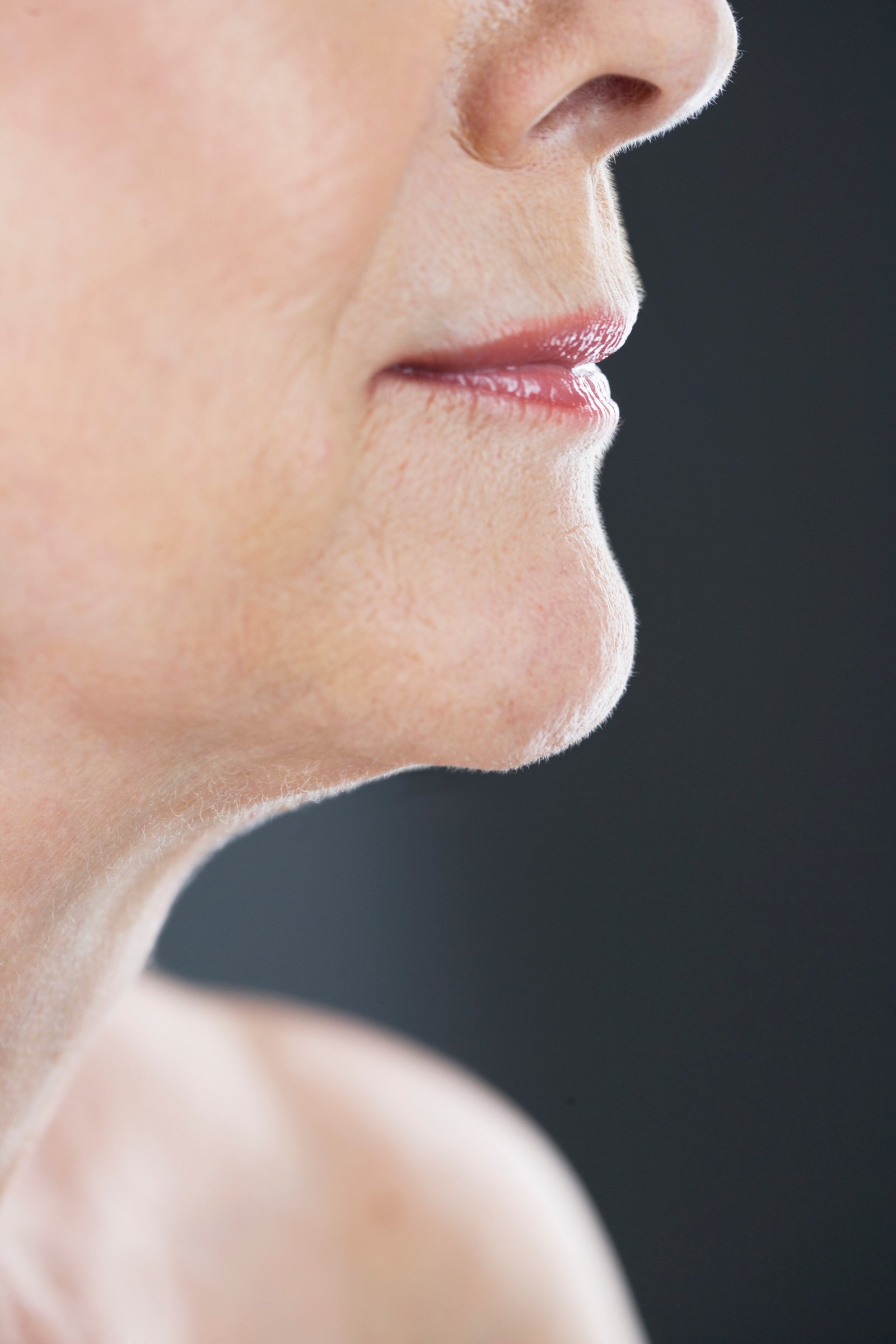 Profile of a mature woman's jaw and neck in low, directional light