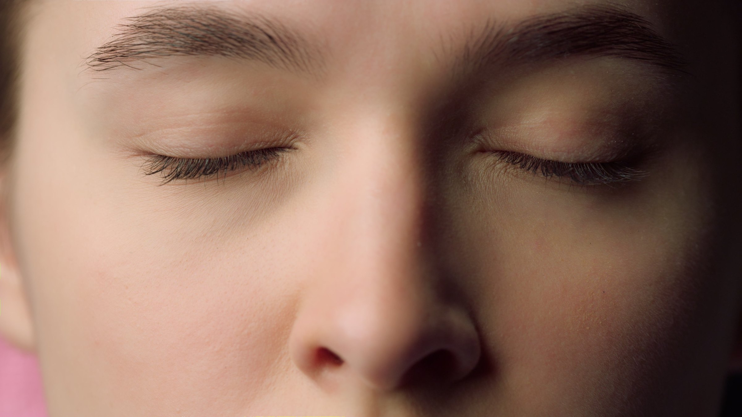 Softly lit close-up of relaxed eyes and eyebrows