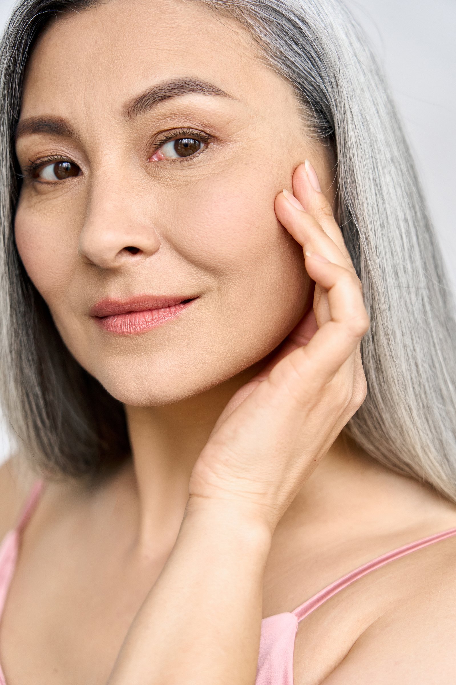 Portrait of a silver-haired woman resting one hand against her cheek
