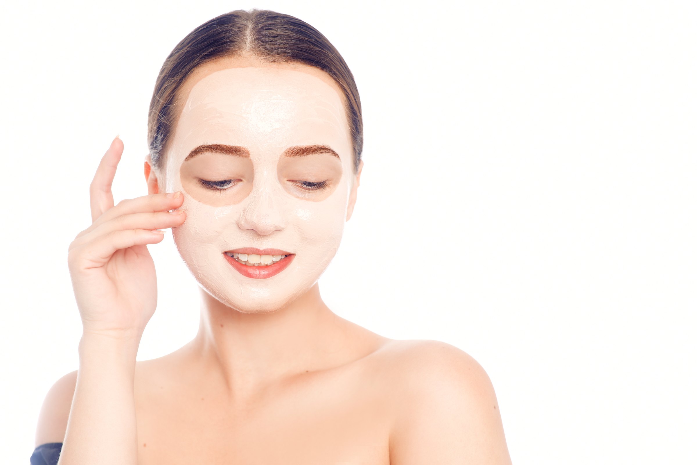 Close beauty portrait of a woman with one hand raised to her face, white background