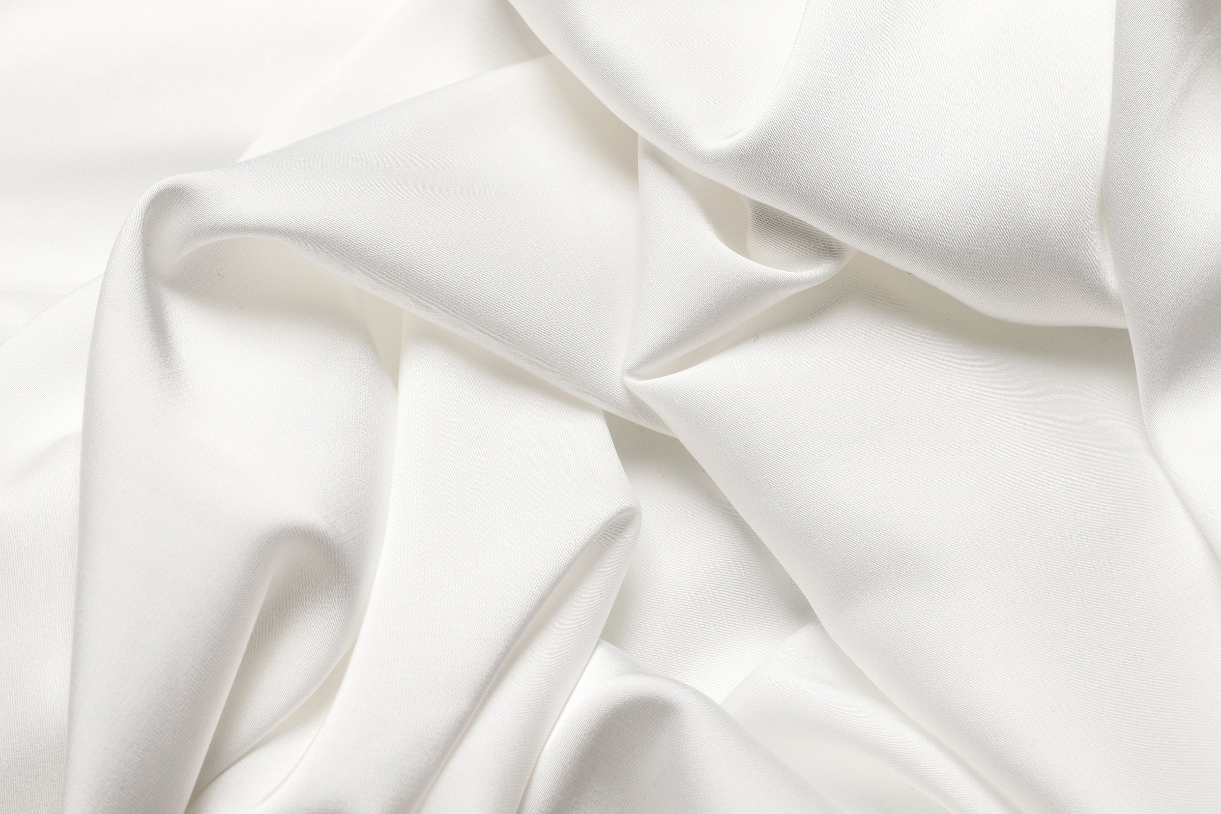 Softly draped cream silk fabric, abstract