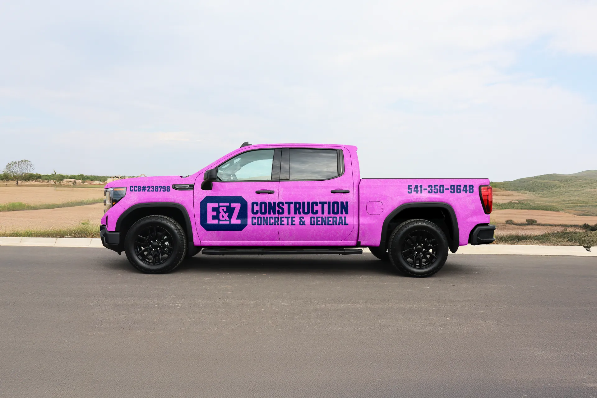 Purple pickup truck with black wheels parked on a road, featuring branding for E&Z Construction Concrete & General, phone number 541-350-9648, and license number CCB#238798.
