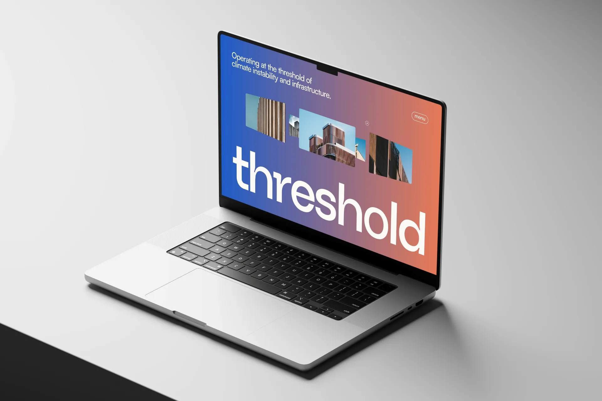 Laptop open on gray table open to Threshold website homepage.