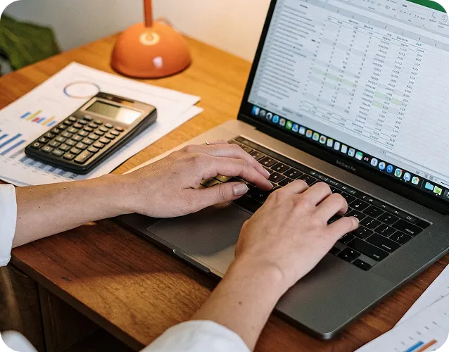 Dłonie na klawiaturze laptopa przy biurku