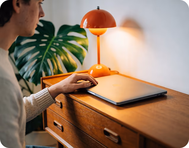 Dłonie na klawiaturze laptopa przy biurku