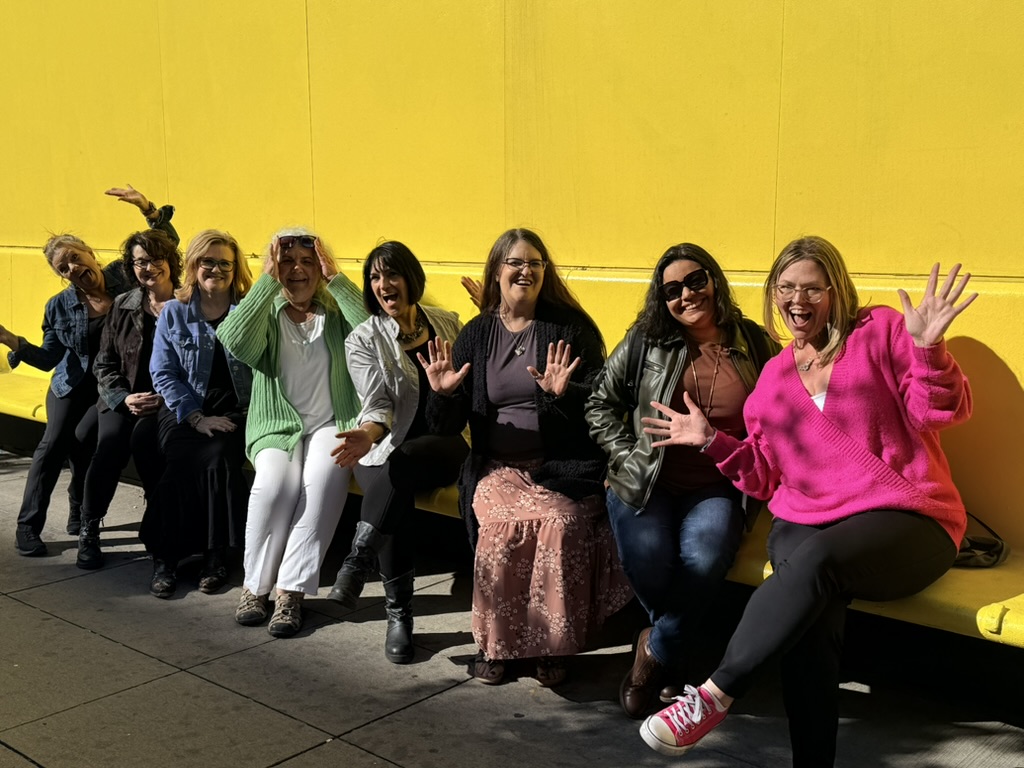 Plandipity Doers team posing joyfully against bright yellow wall background