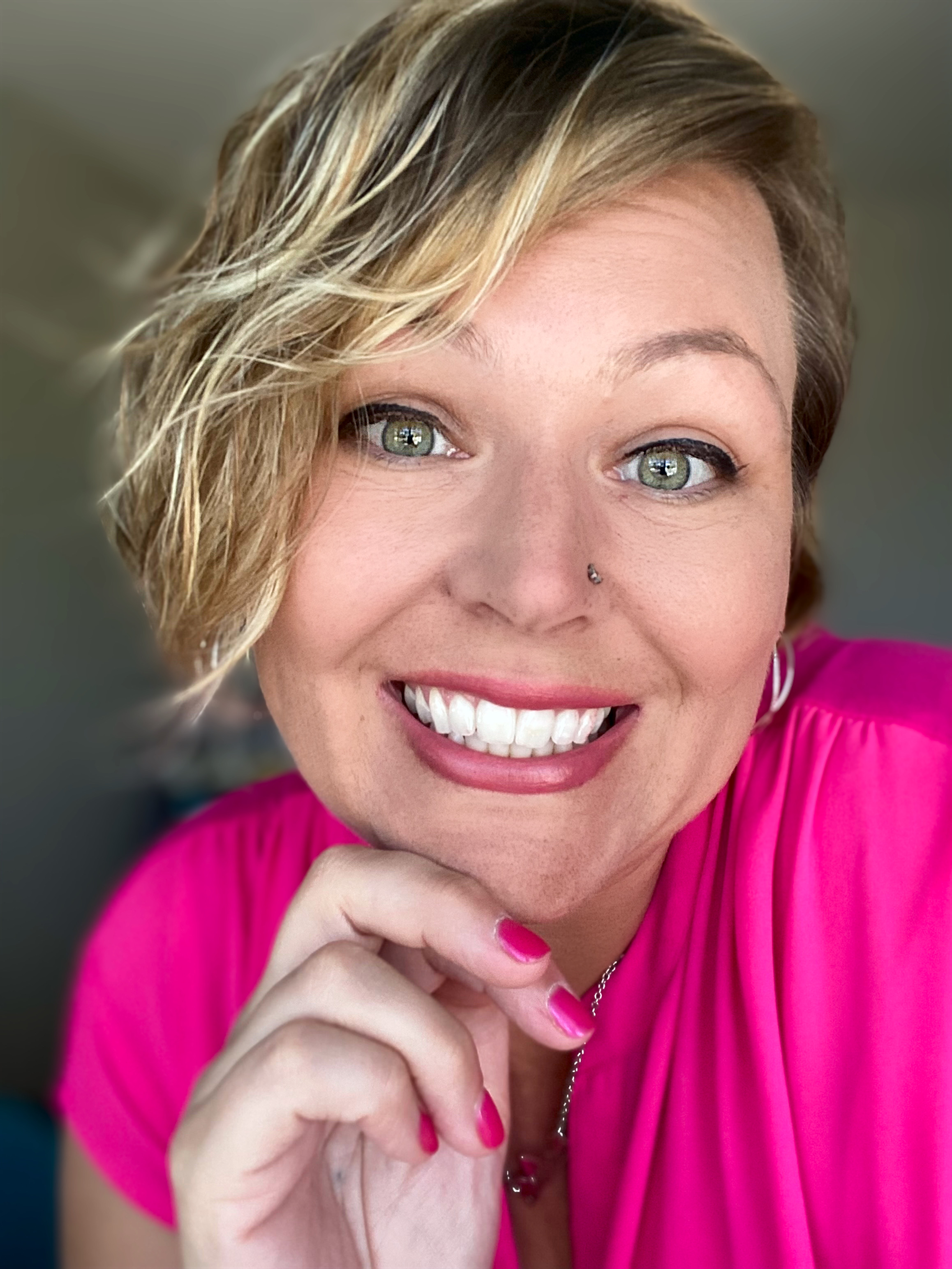 Samantha Markey smiling portrait wearing bright pink shirt and hoop earrings