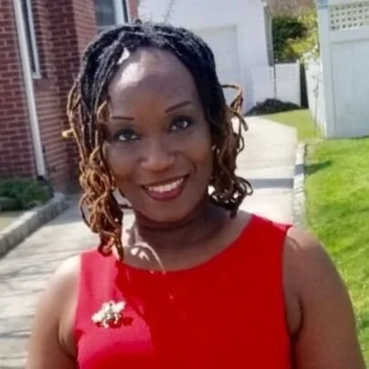 Mrs. Leathers smiling outdoors in a red top