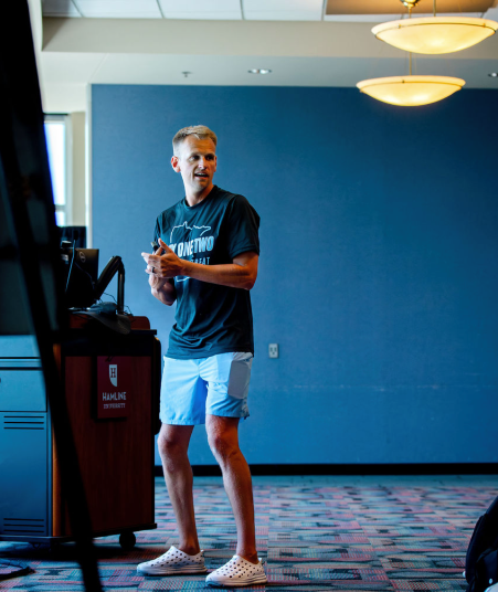 Man giving a presentation indoors while speaking to an audience.