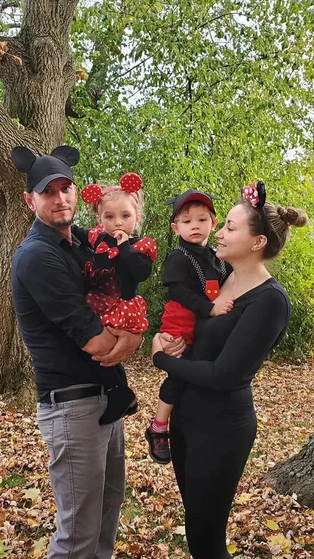 Christopher Morawski, owner of Purpose Contracting Asphalt, with his family wearing matching Mickey and Minnie Mouse costumes outdoors among fall leaves