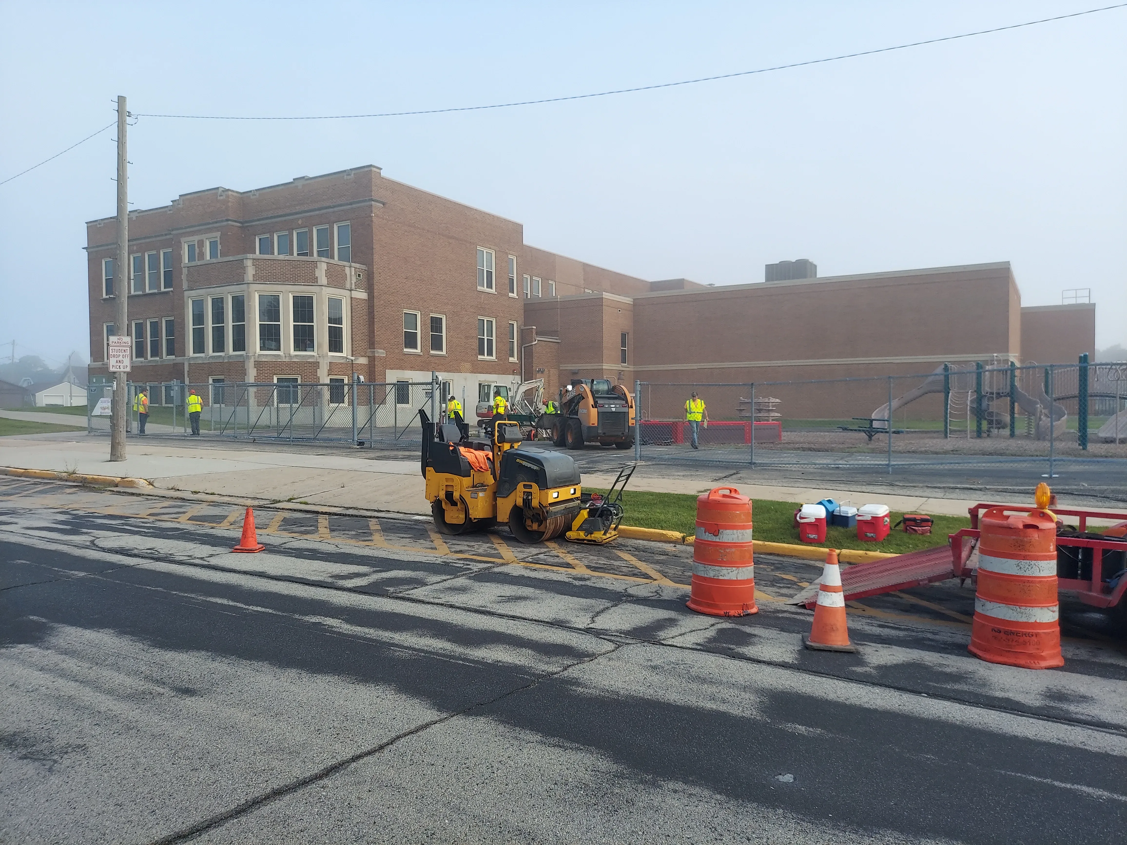 Asphalt paver laying hot mix on a school lot
